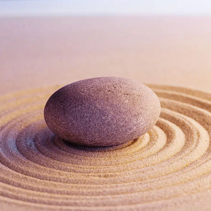 Ronde steen in een patroon met zand - Core Connection - Begeleiding coach